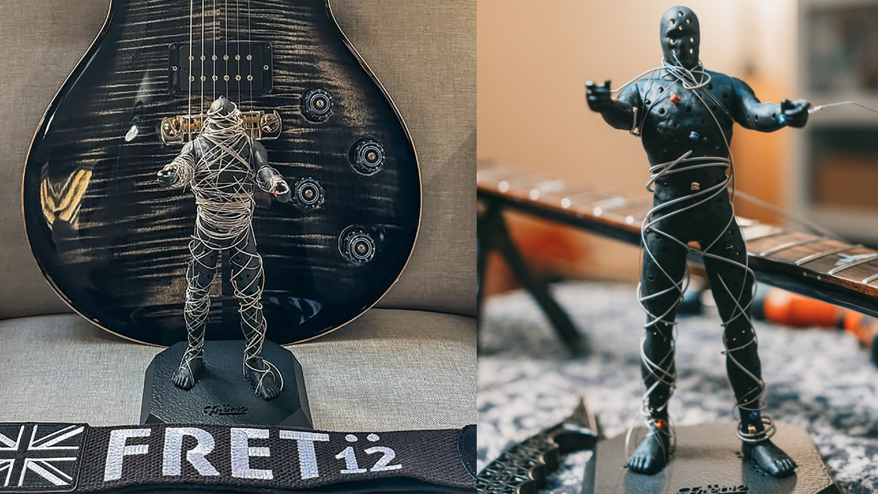 String Thing mummy figurine wrapped in recycled guitar strings displayed in front of an electric guitar.
