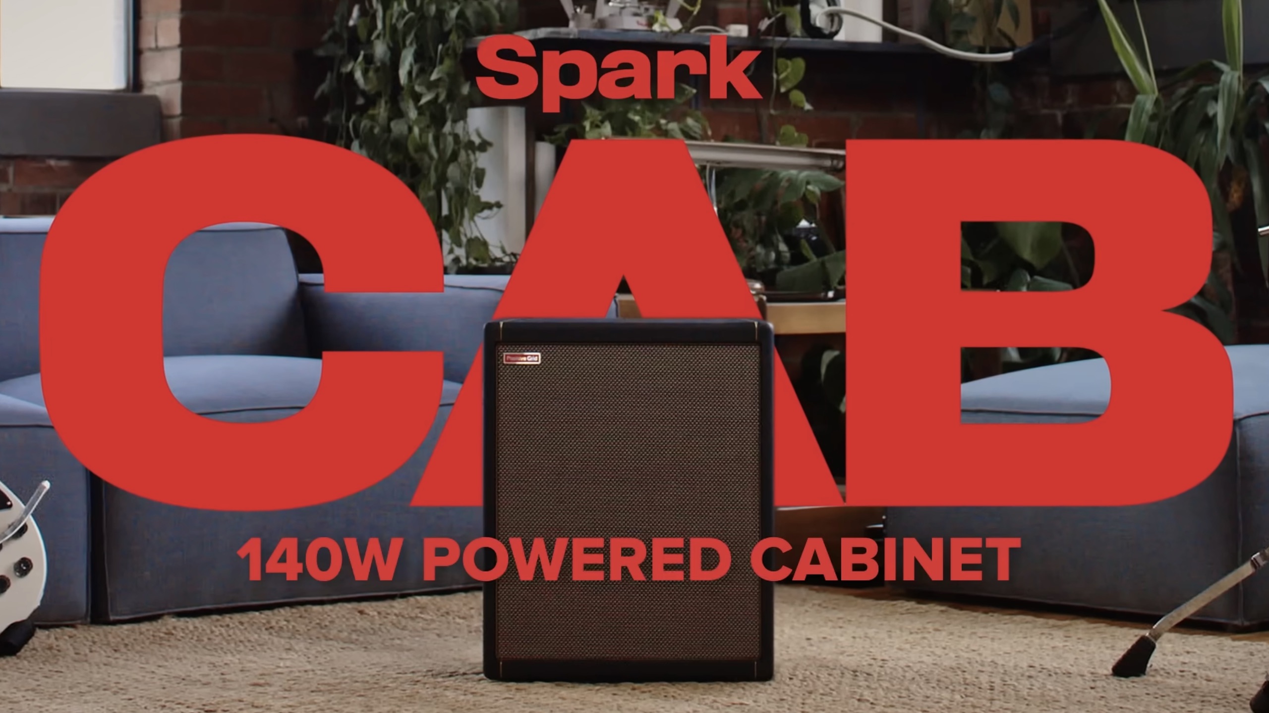Promotional image for the Spark CAB 140W powered guitar cabinet, featuring a compact black speaker cabinet centered between blue couches in a modern studio setting with large red “CAB” text overlay.